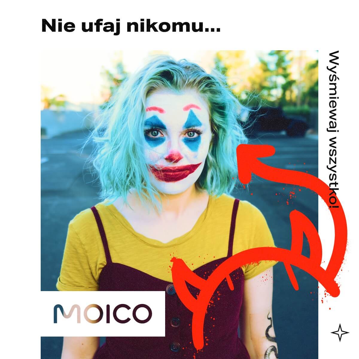 Grafika przedstawia kobietę z jasnoniebieskimi włosami, ubrana jest w żółto-bordowy top. Twarz kobiety jest pomalowana na biało z akcentami niebieskimi i czerwonymi. W górnej części obrazu znajduje się tekst w języku polskim: „Nie ufaj nikomu...”, co oznacza „Nie ufaj nikomu...”. Po prawej stronie obrazka widnieje kolejny tekst: „Wyśmiewaj wszystko!”. Czerwona strzałka wskazuje na osobę na zdjęciu, a w lewym dolnym rogu znajduje się logo „MOICO”.